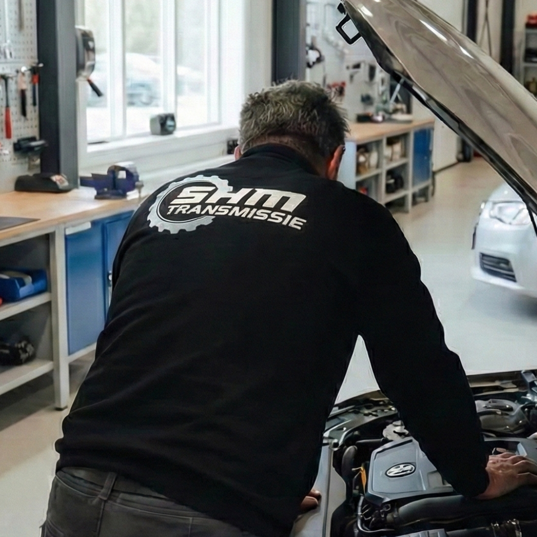 Monteur leunend over motorkap Monteur leunend over motorkap